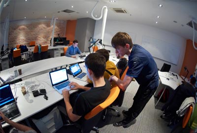 Dos profesionales trabajando con ordenadores en oficina